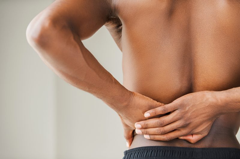 A man holding his lower back.
