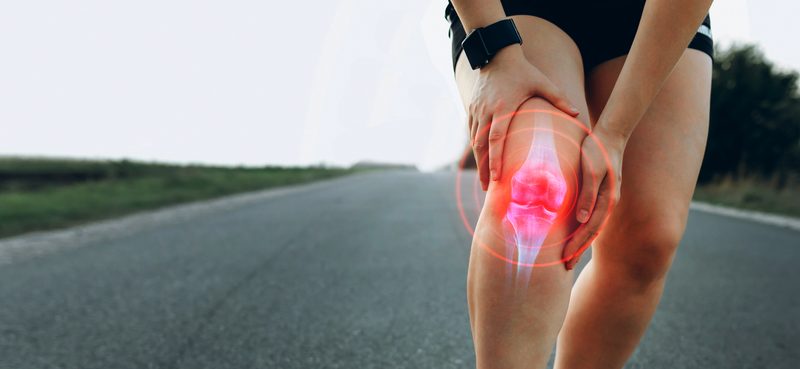 A woman holding her knee with an x-ray-style overlay.