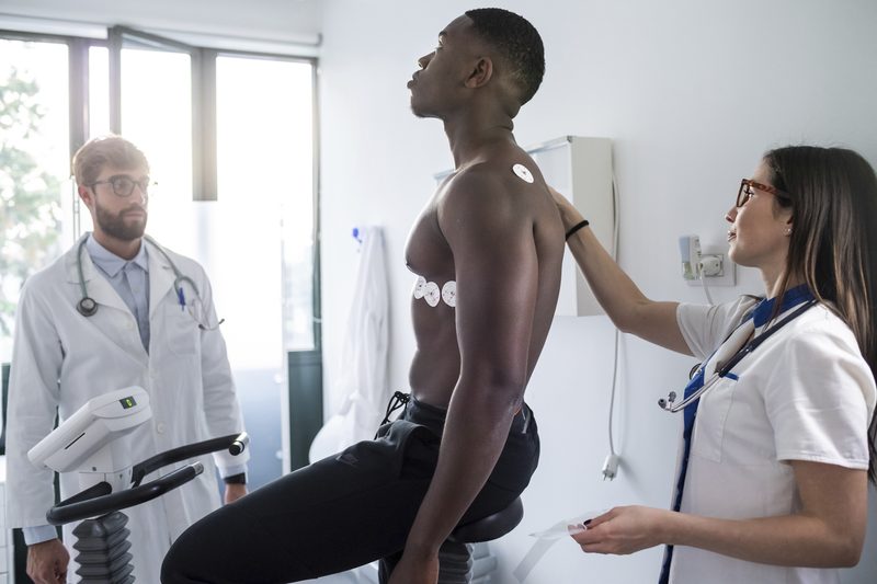 A clinician monitoring an adult during a stress-test exam.